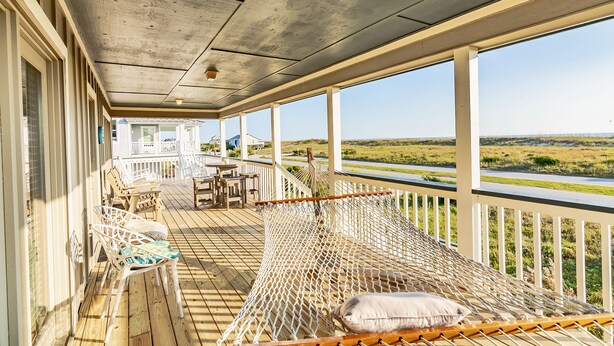 A covered porch with a hammock, chairs, and a view of the landscape. - Panoramic views from the wrap around porch overlooking south bald head (Bald Head Island)