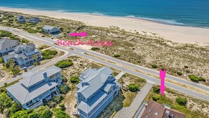 An aerial view of a coastal area with beachfront properties, roads, and a beach. - Panoramic views from the wrap around porch overlooking south bald head (Bald Head Island)
