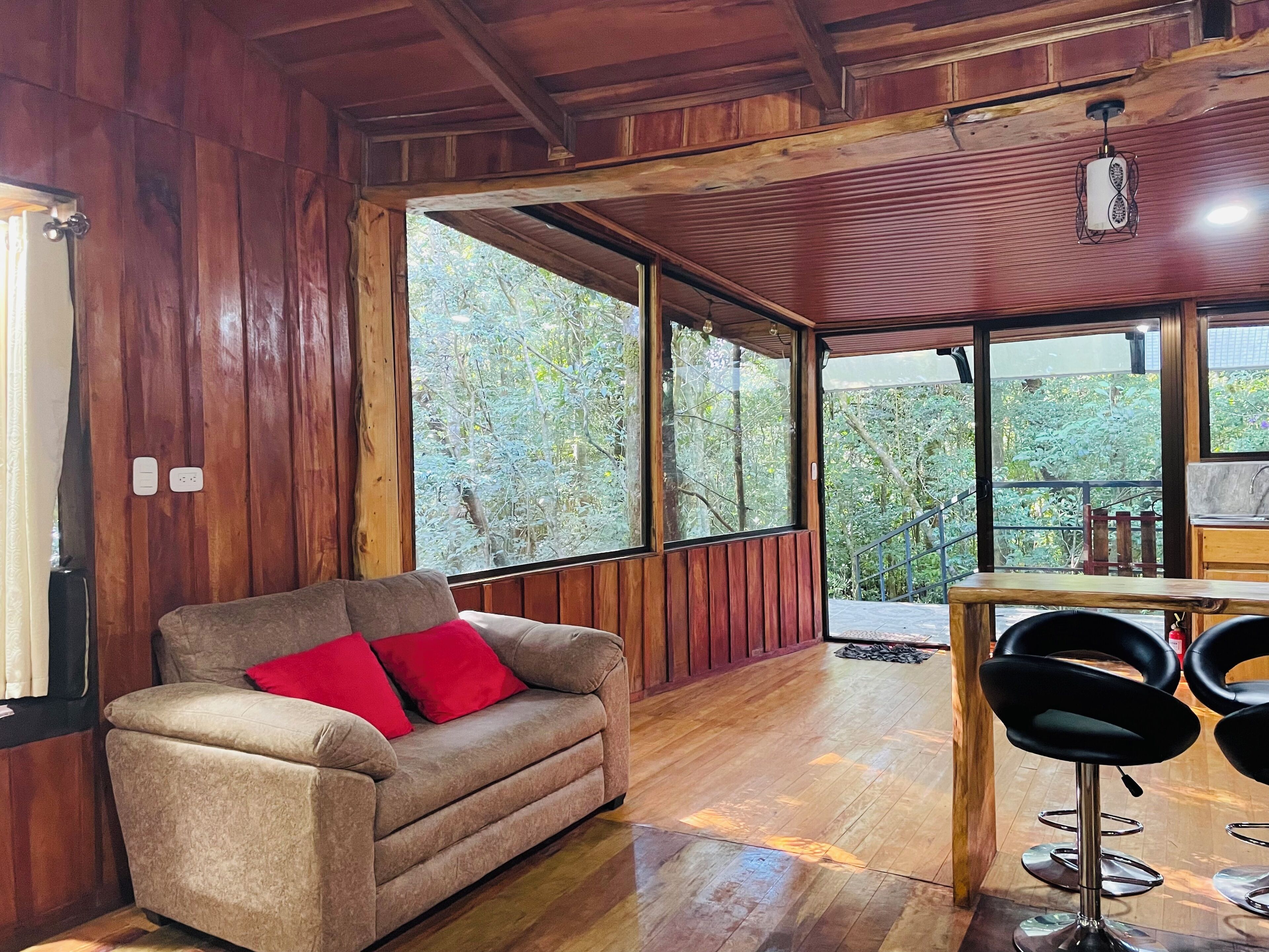 A wooden interior with a sofa and a dining area.