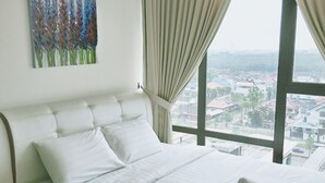 A hotel room with a large bed, white bedding, a painting on the wall, and a view of a cityscape through the window. - South Key Mosaic (Johor Bahru)