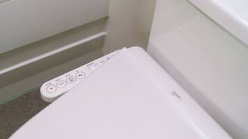 Een wit toilet met bedieningspaneel, inclusief knoppen en een display.