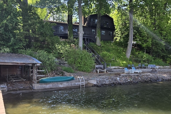 Front view of property - dock at left, beach in foreground, house up top
