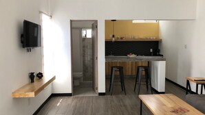 Kompakti asuintila, jossa on pieni keittiö, ruokailutila ja kylpyhuone.