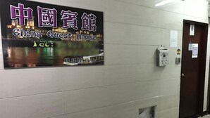 A hallway with a sign for 'China Guest House' and a door to the right. - China Guest House (Kowloon)