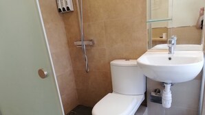 A bathroom with a toilet, a shower, and a sink. - China Guest House (Kowloon)