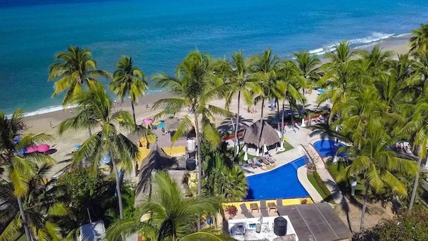 A beach resort with palm trees, a swimming pool, and a view of the ocean. - Villa Robalo - Villas del Palmar (Sayulita)