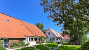 A row of houses with red roofs and a well-maintained lawn.