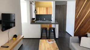 Un apartament modern amb cuina, zona de menjador i saló.