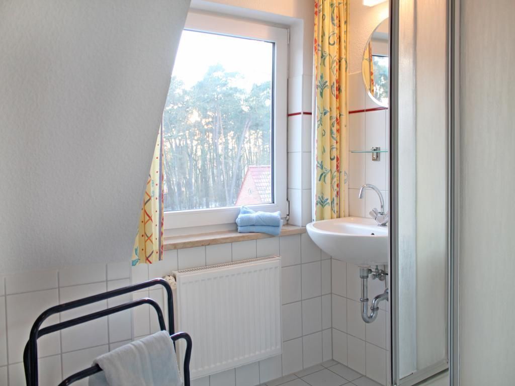 Une salle de bain avec une fenêtre, un lavabo et un porte-serviettes.