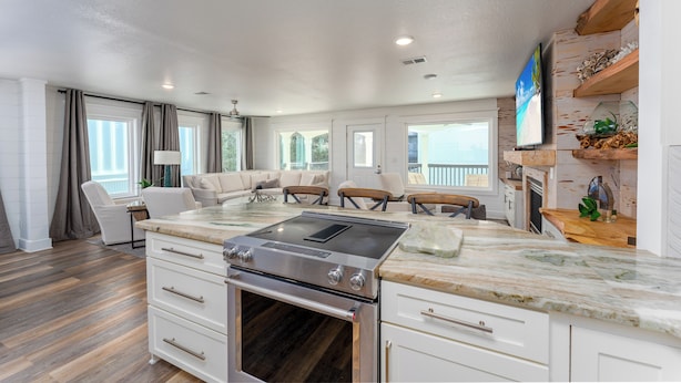 A modern kitchen with a built-in stove, white cabinetry, and a large window overlooking a balcony. - Seagrove, Amazing Gulf Views, Great Beach Access, Heated Pool, Pup Friendly
 (Santa Rosa Beach)