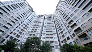 Een hoog appartementencomplex met meerdere balkons en een centrale binnentuin.