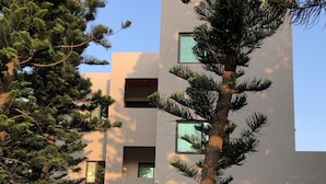 A modern building with a flat roof, multiple windows, and a gated entrance. - Araucaria Residence (Huxi)