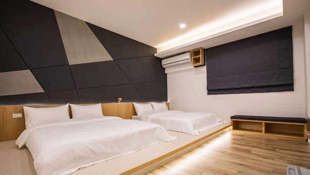 A modern bedroom with two beds, wooden flooring, a geometric wall design, and built-in storage. - Araucaria Residence (Huxi)