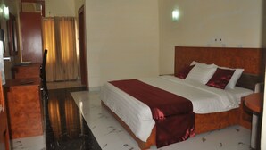 A hotel room with a large bed, a desk, and a chair. - Top Rank Hotel (Abuja)
