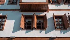 Un edificio de varios pisos con balcones de madera y ventanas grandes.