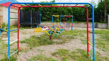 Kids can play on swings, slides, and climbing elements in this outdoor playground.