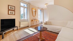 A modern living room with a TV, sofa, and a patterned rug.