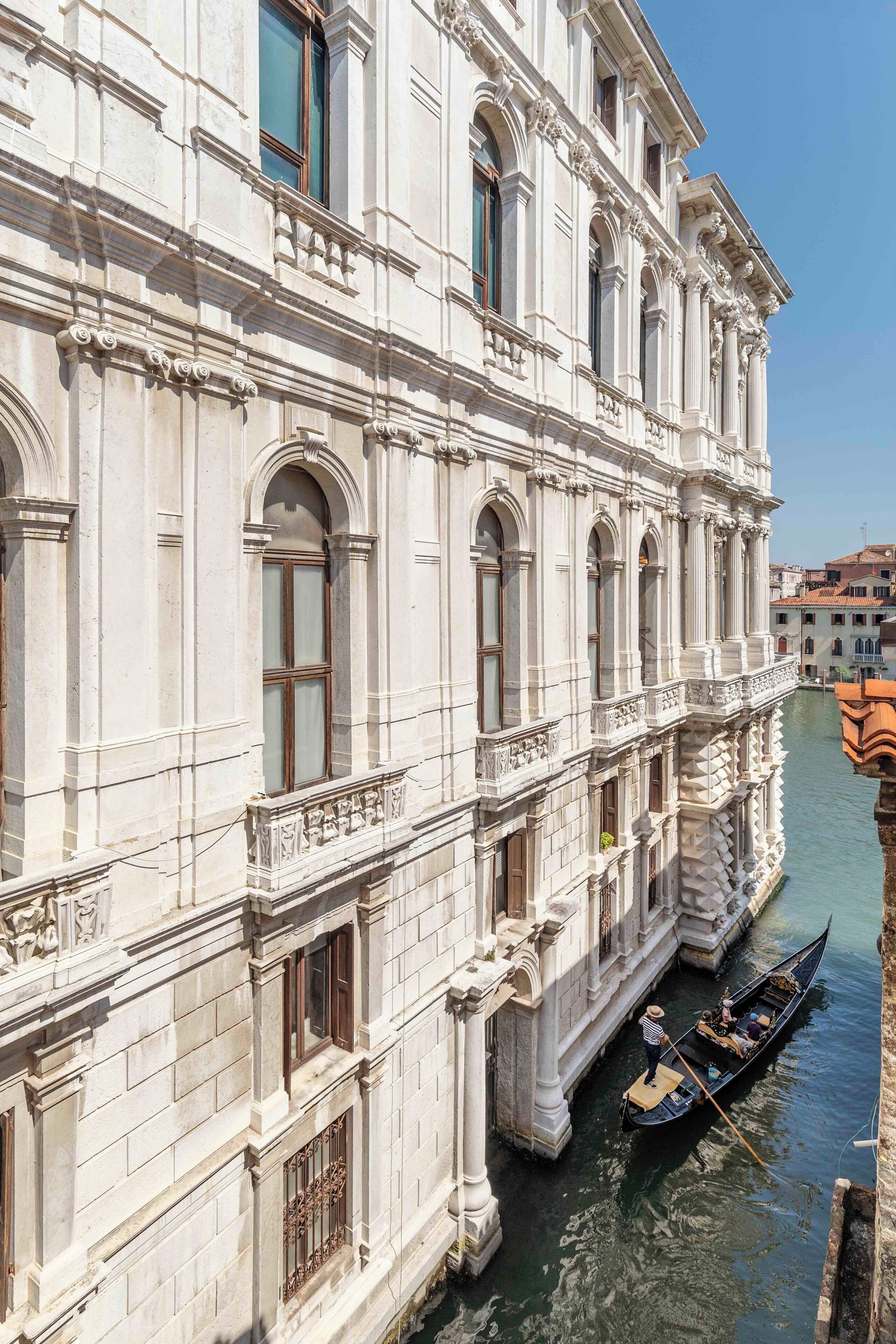 Ein historisches Gebäude mit klassischer Architektur, ein Kanal und eine Gondel.
