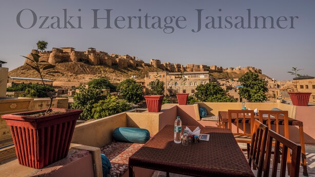 Eine Terrasse mit Tisch und Stühlen mit Blick auf eine historische Festung.