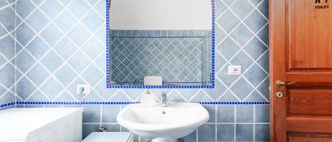A bathroom with a white sink, a mirror, and a toilet.
