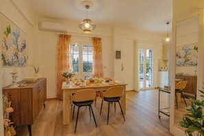A spacious kitchen with wooden cabinets, a dining table with chairs, and a view to the outside.