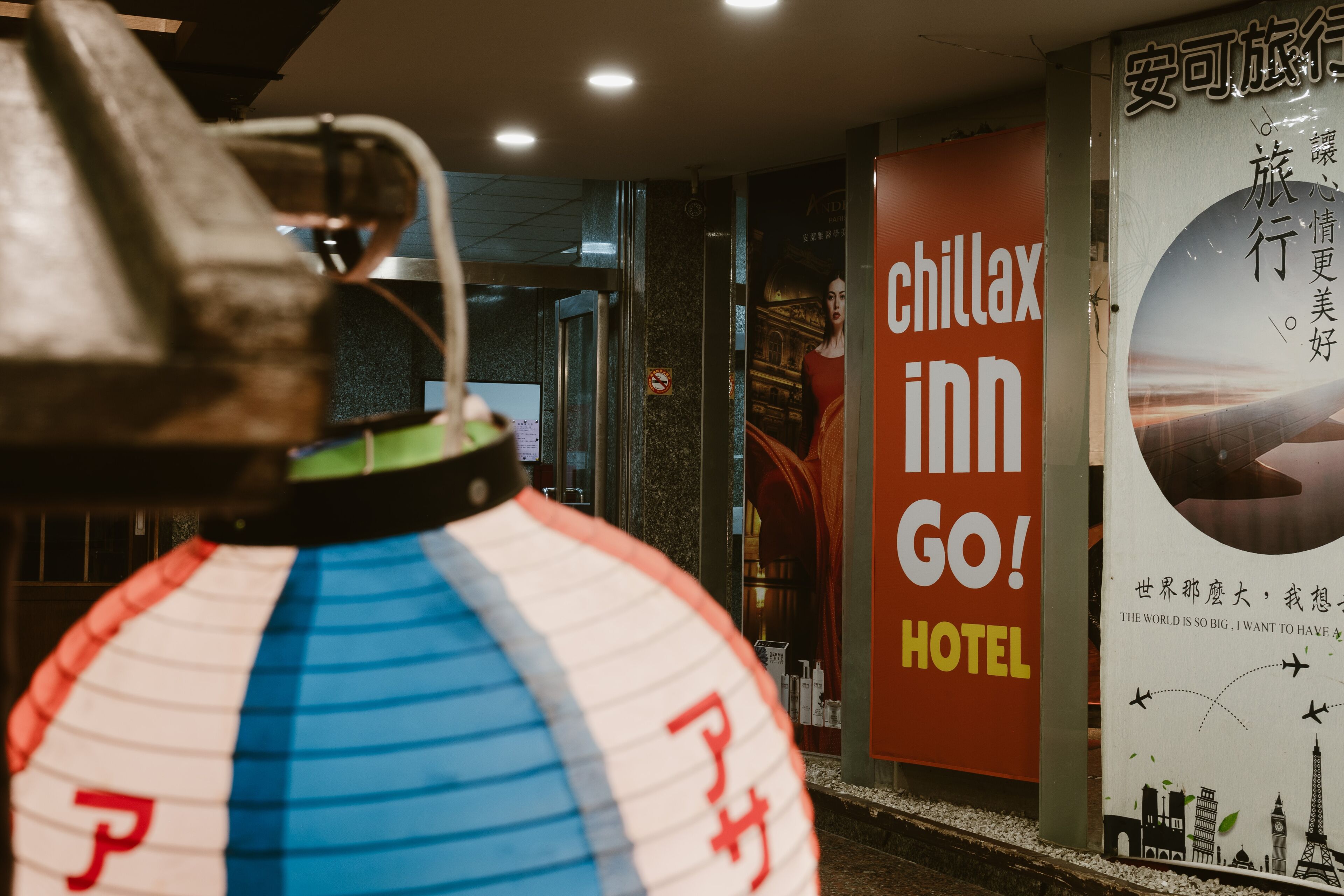 Une enseigne publicitaire pour l’hôtel Chillax Inn, avec une vue sur l’intérieur.