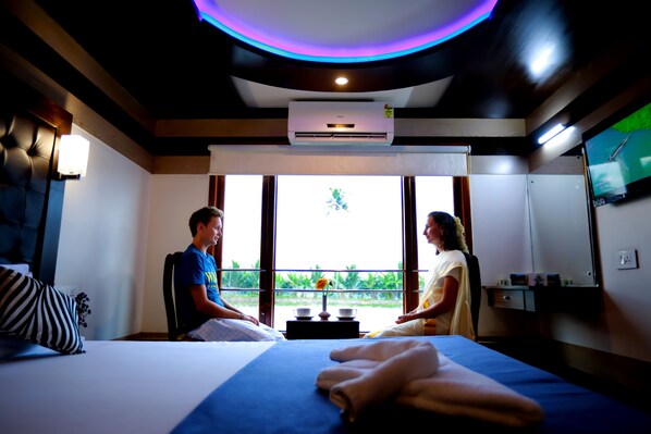 A room with a bed, a massage table, a massage therapist, and a client.