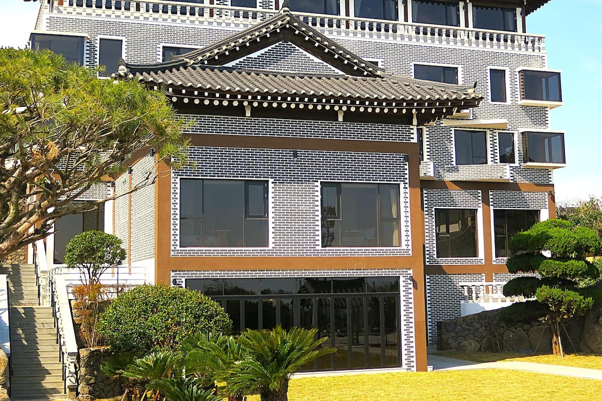 Un edificio tradicional con fachada moderna, que presenta amplios ventanales y tejado de tejas.