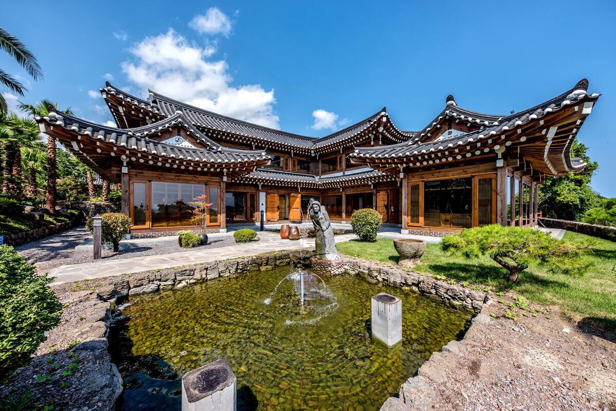 Un edificio japonés tradicional con un estanque de carpas al frente.