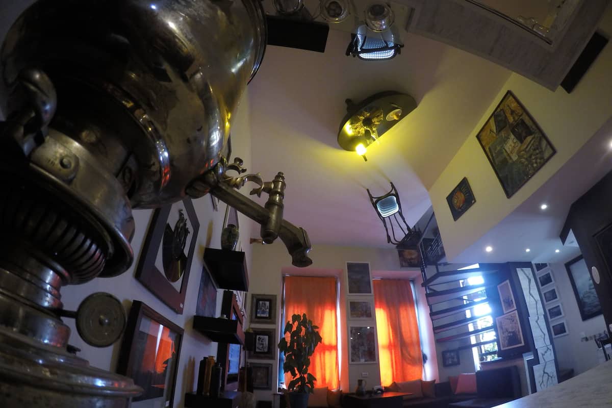 A living room with a large brass radiator, a sofa, a coffee table, and a potted plant.