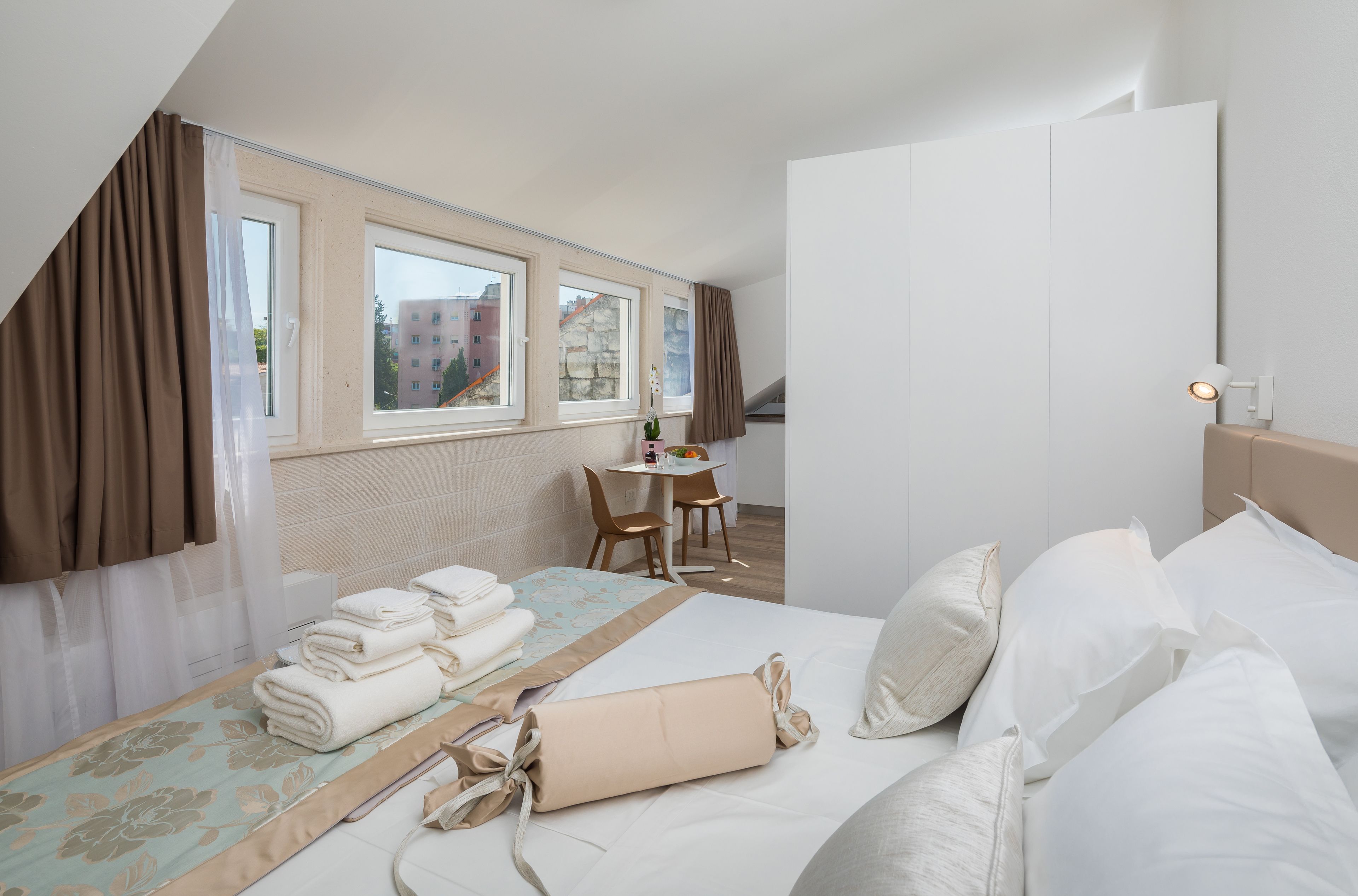 A hotel room with a bed, a desk, and a chair.