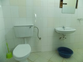 Baño con inodoro, lavabo y lavamanos azul.