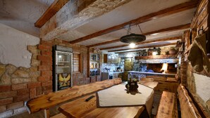 Eine rustikale Küche mit freiliegenden Backsteinwänden, Holzbalken und einem großen Holztisch.