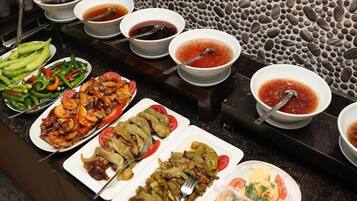 A buffet with various dishes and sauces.