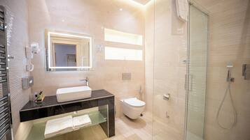 Een moderne badkamer met een douchecabine van glas, een wastafelmeubel met een wastafel en een toilet.