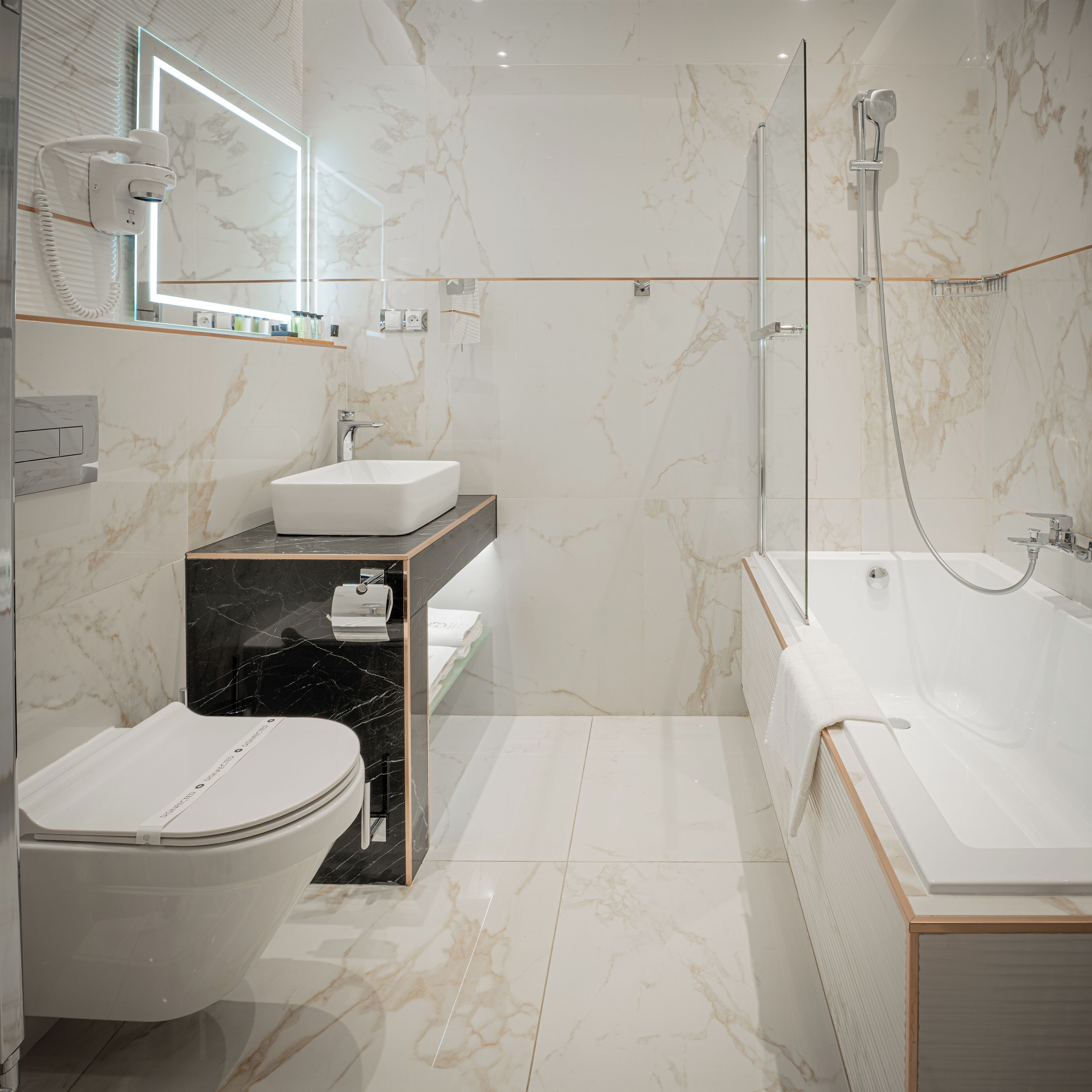 Ein modernes Badezimmer mit Toilette, Waschbecken und Badewanne.