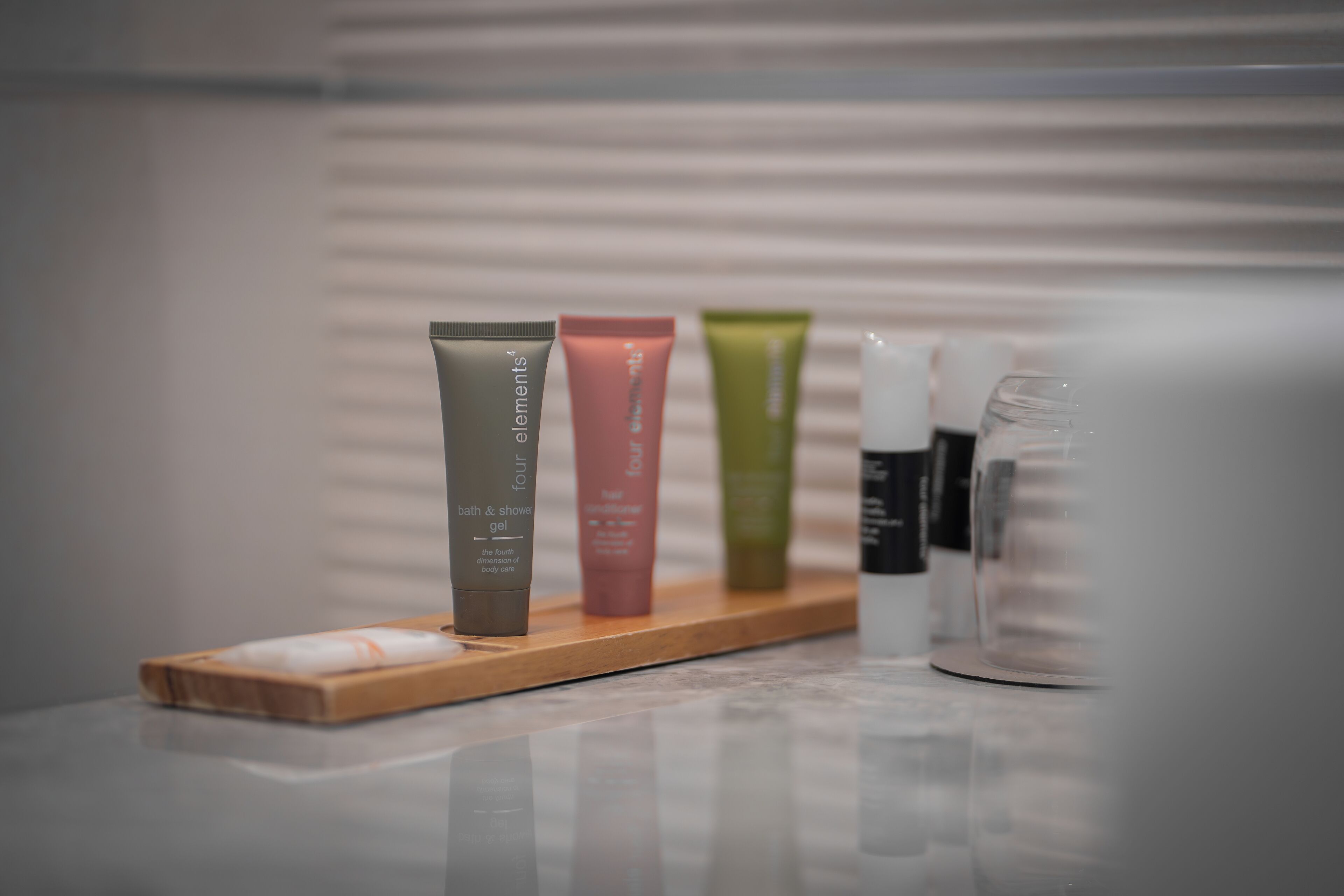 Estante de baño con cuatro botellas de gel de ducha y baño.
