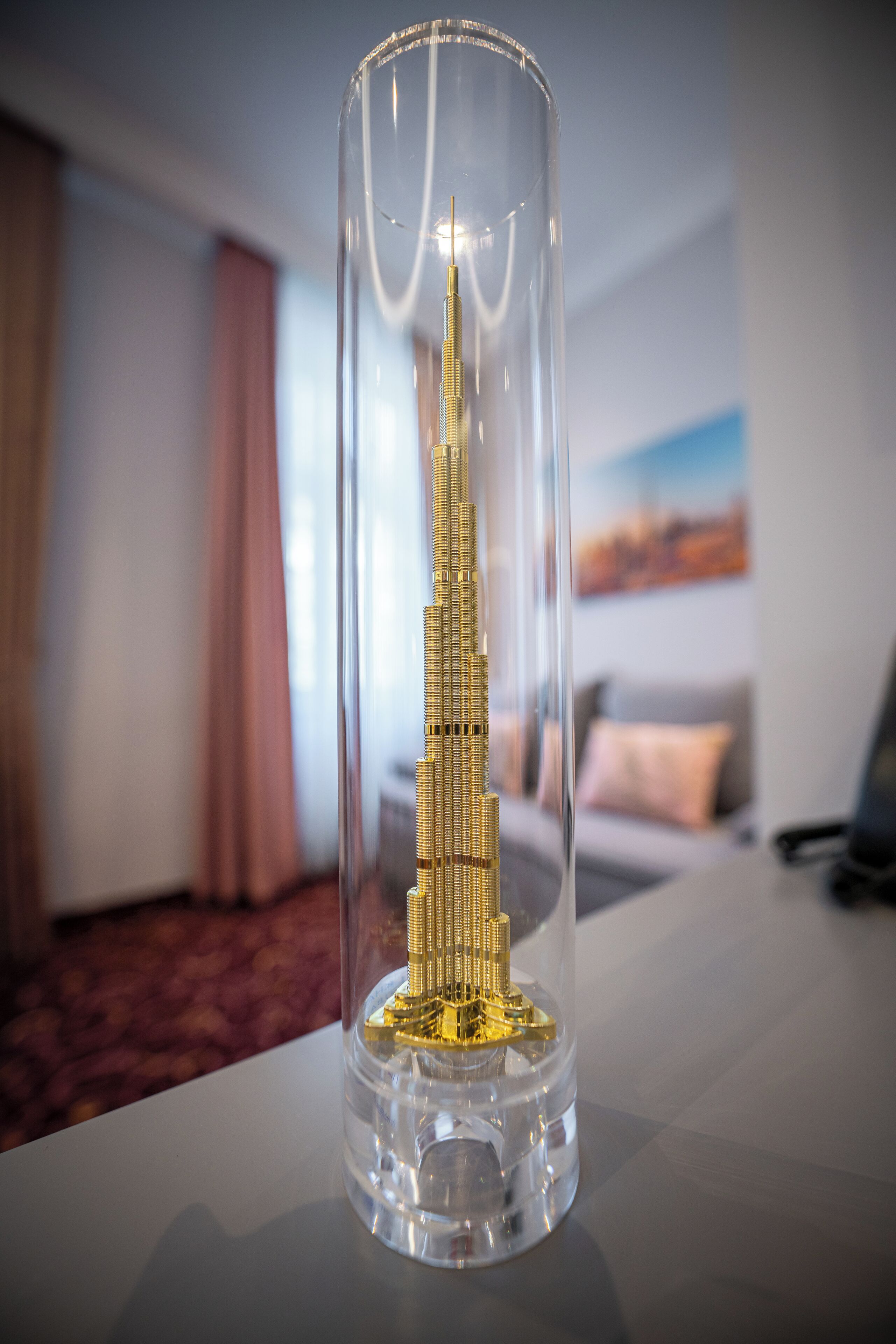 Een model van de Burj Khalifa in een glazen koepel op een tafel.