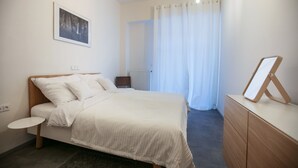 A bedroom with a bed, bedside table, dresser, and a framed picture on the wall. - Apartments At The Blue Duckling (Prague)