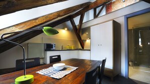 A kitchen with a wooden table, a green lamp, and a microwave. - Apartments At The Blue Duckling (Prague)