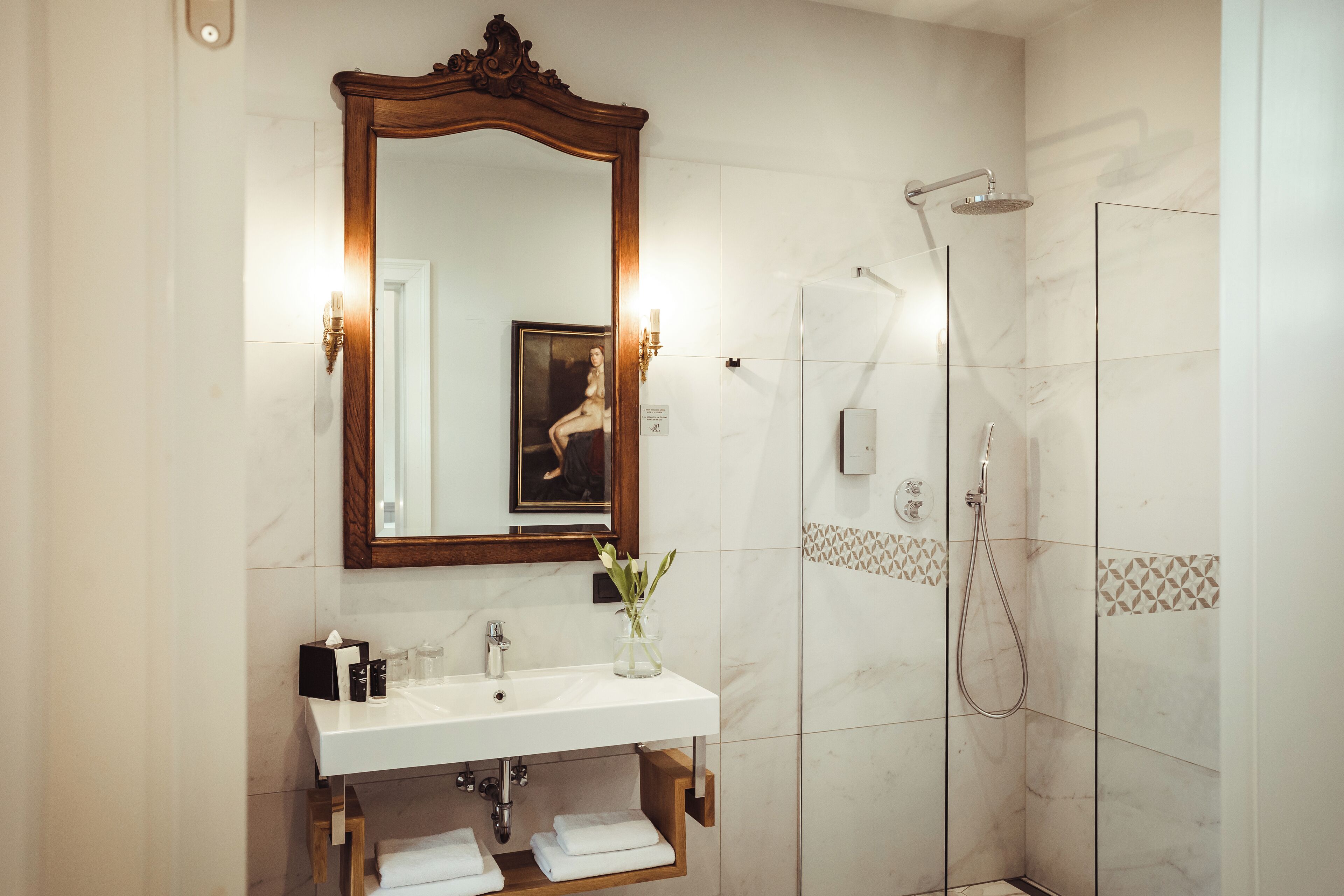 Un baño con lavamanos, espejo y ducha blancos.