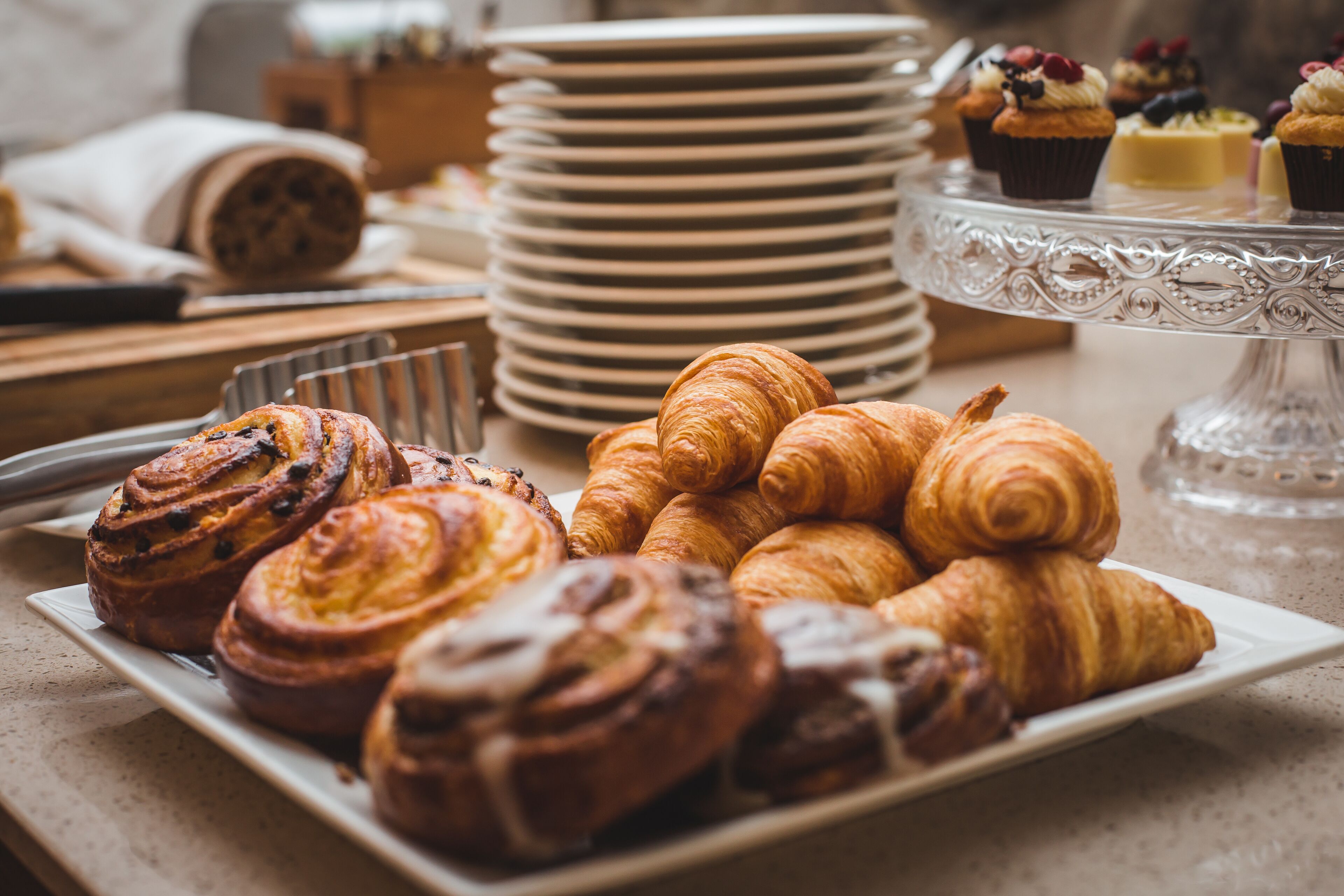 A variety of pastries on a plate, including croissants and cinnamon rolls.