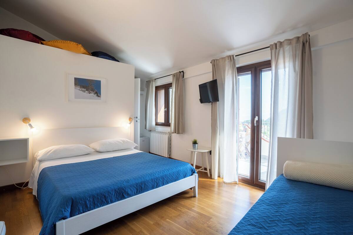 Habitación triple Confort, vista a la montaña | Edredón, cortinas blackout y ropa de cama