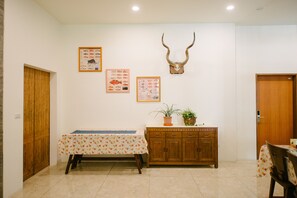Un espace repas comprenant une table, un meuble en bois et des éléments de décoration fixés au mur.