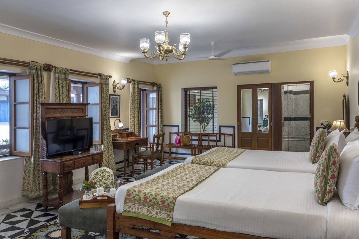 A hotel room with a bed, desk, television, and a view of the outside.