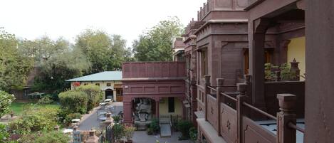 Un patio con plantas en macetas, mobiliario exterior y un edificio de arquitectura tradicional.