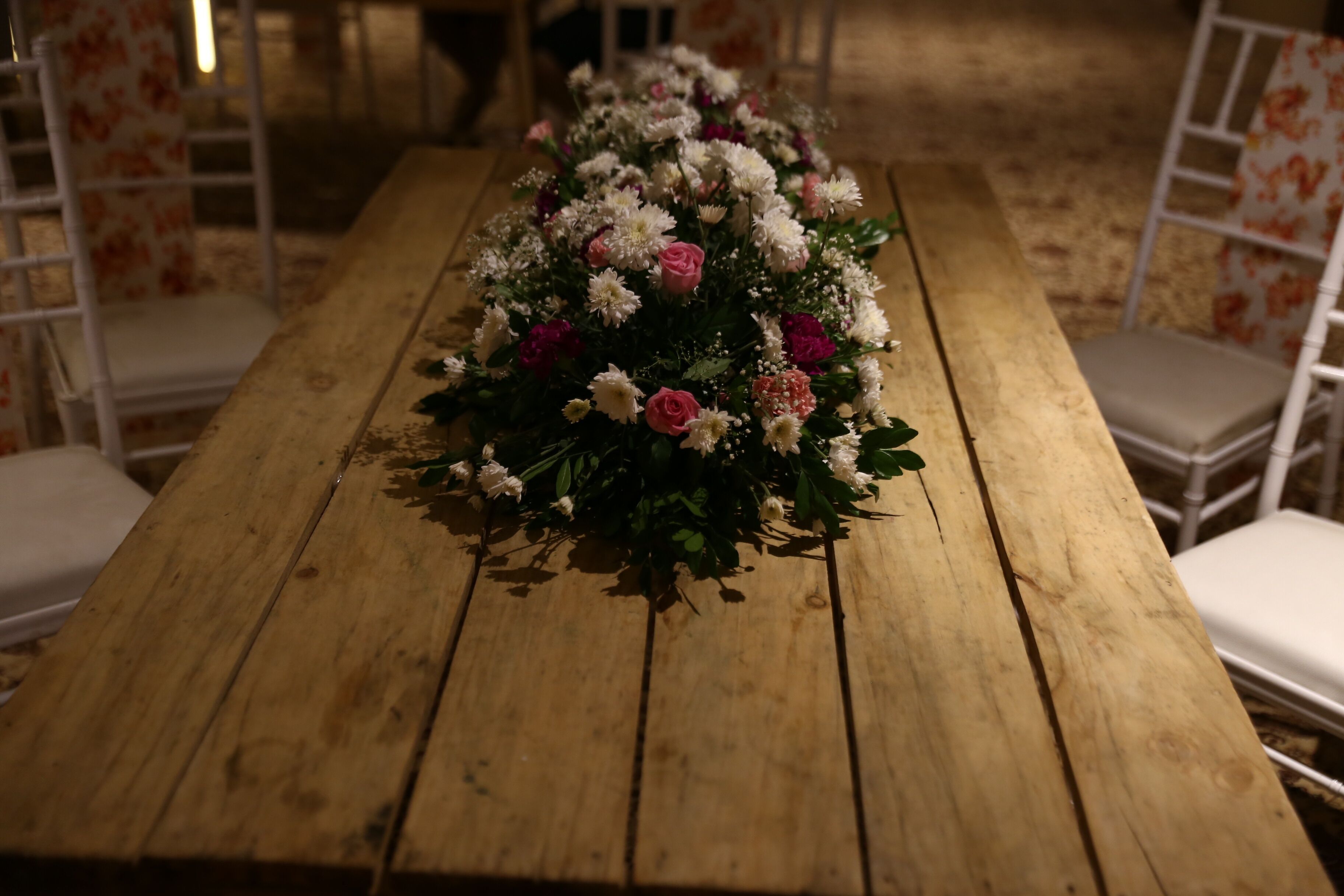 Ein Holztisch mit einer floralen Dekoration.