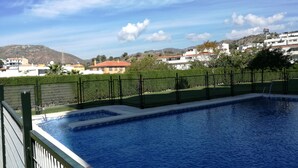A swimming pool with a view of surrounding buildings and hills.