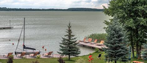 Une vue sur le lac avec un quai, des chaises et une table de pique-nique.
