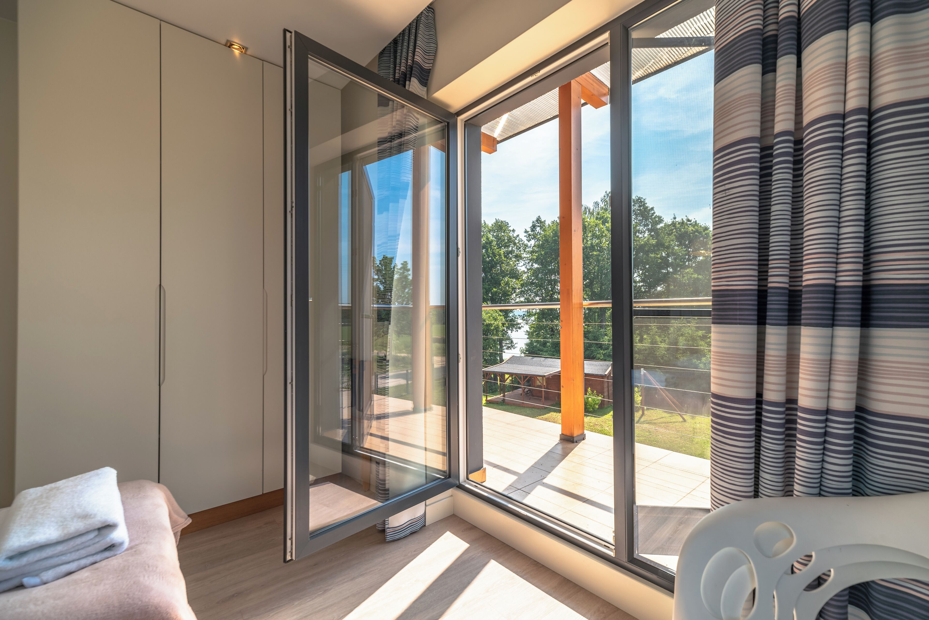 Una habitación moderna con un amplio ventanal corredero que da a un patio exterior.